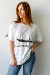 Woman wearing a white graphic t-shirt with text and a design.