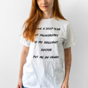 Woman wearing a white tee with bold black text.