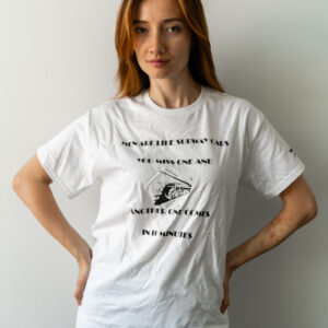 Woman wearing a white t-shirt with a black text and graphic design.
