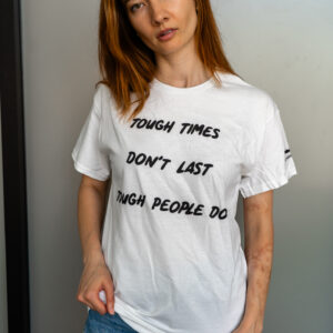 Woman wearing a white t-shirt with a motivational quote.