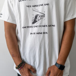 Person wearing a white graphic tee with text and an image on it.