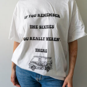 Person wearing a white T-shirt with black text and a small vehicle graphic.
