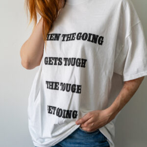 Person wearing a white T-shirt with bold black text.